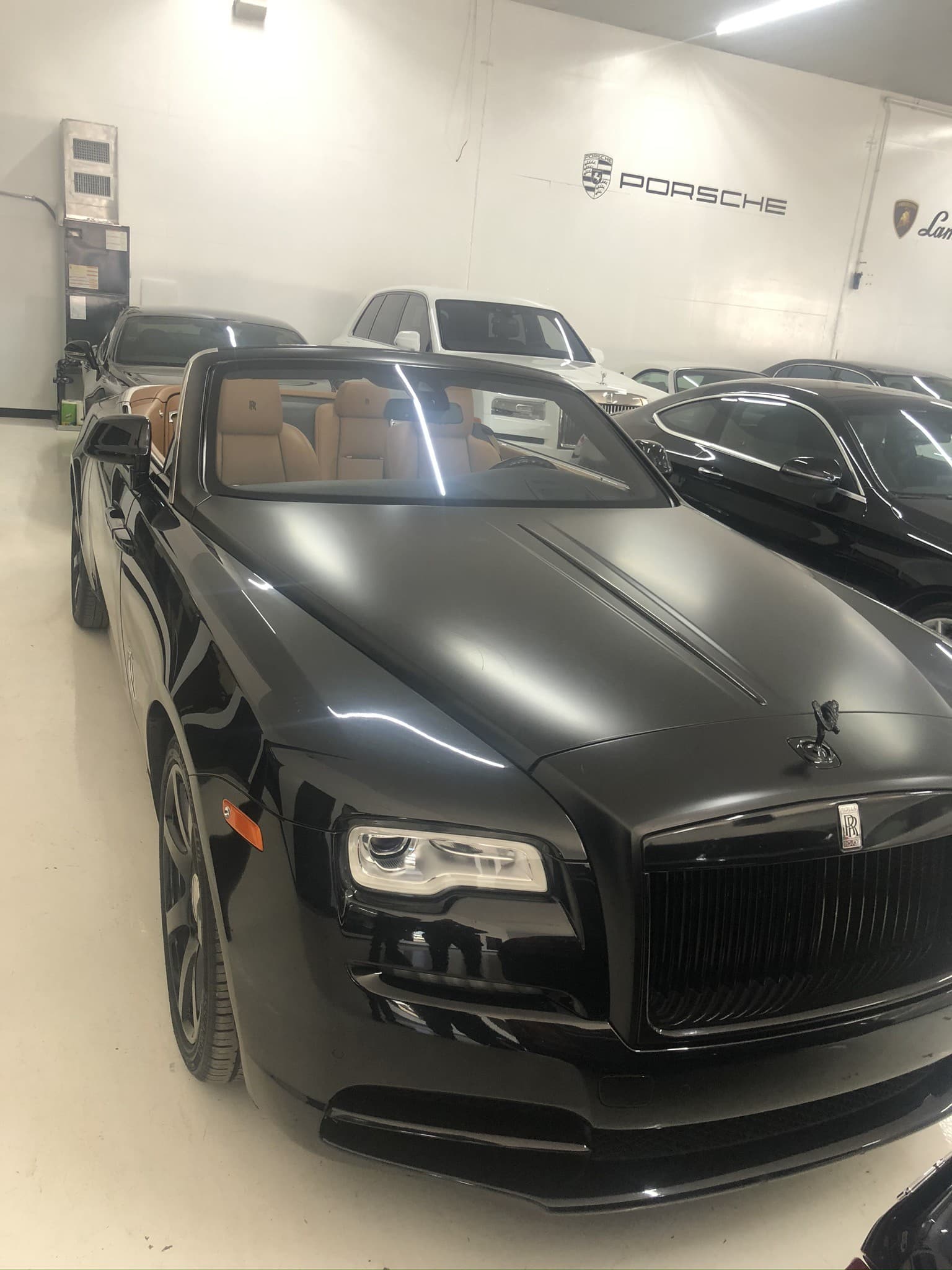 Rolls-Royce Dawn convertible in black, top down, beige interior visible